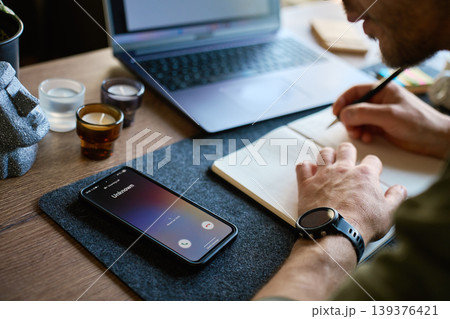 Unknown phone call during work at desk with notebook Unknown phone call during work at desk with notebook 139376421