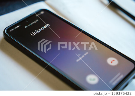 Smartphone screen with unknown incoming call on desk 139376422