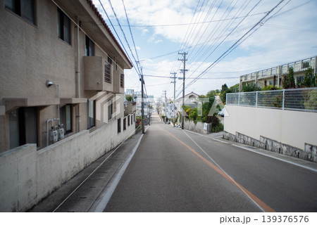 遠くに街の見える住宅街の真っ直ぐで緩やかな坂道 遠くに街の見える住宅街の真っ直ぐで緩やかな坂道 139376576