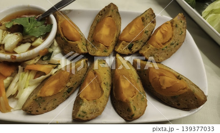 Traditional Thai Fried Fish Cakes Stuffed with Salted Egg Yolk and Sweet Chili Sauce Traditional Thai Fried Fish Cakes Stuffed with Salted Egg Yolk and Sweet Chili Sauce 139377033