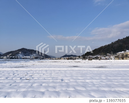 晴れた冬の日の雪原と山並み 139377035