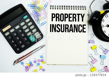 Property Insurance text written on notepad with calculator and alarm clock Property Insurance text written on notepad with calculator and alarm clock 139377634