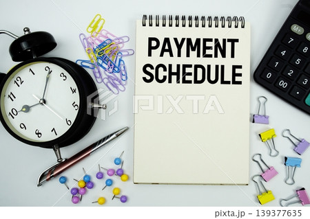 Payment Schedule text written on notepad with calculator and alarm clock 139377635