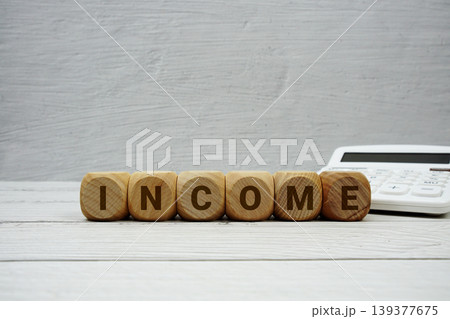 INCOME alphabet letters with calculator on wooden background INCOME alphabet letters with calculator on wooden background 139377675