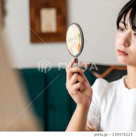 女性が手鏡を覗く 女性が手鏡を覗く 139378125