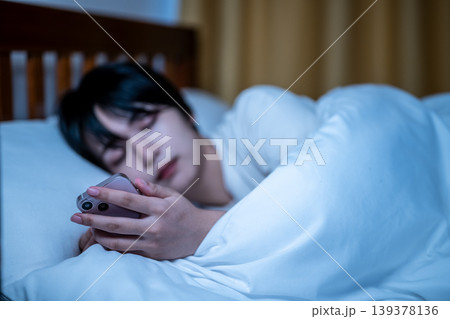 ベッドでスマホを見る女性 ベッドでスマホを見る女性 139378136