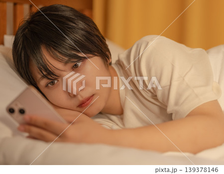 ベッドでスマホを見る女性 139378146