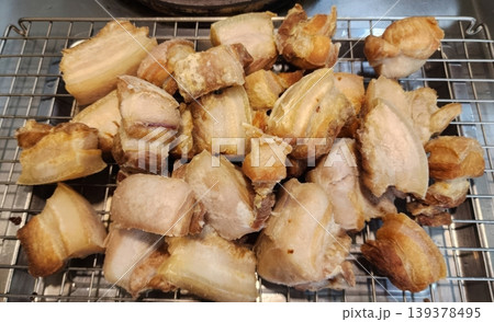 Crispy Deep Fried Pork Belly Chunks Resting on a Metal Cooling Rack 139378495