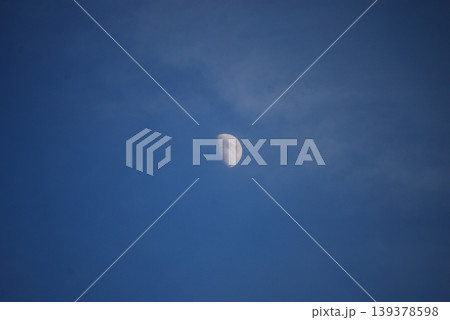 青い空に浮かぶ昼間の半月の風景 青い空に浮かぶ昼間の半月の風景 139378598