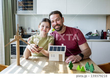 Father teaching daughter about renewable energy and ecology at home. Father teaching daughter about renewable energy and ecology at home. 139379218