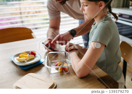 Parent helping diabetic daughter understand nutrition and sugar content. 139379270