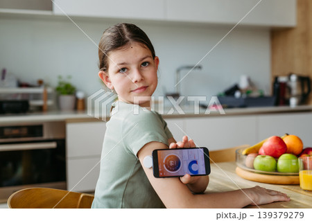 Teen girl with diabetes scanning glucose level using CGM sensor and smartphone. Teen girl with diabetes scanning glucose level using CGM sensor and smartphone. 139379279