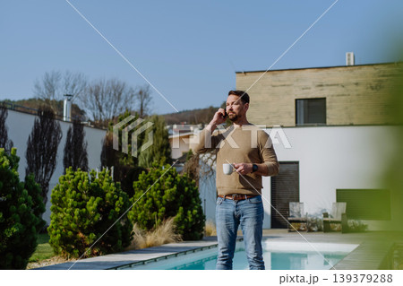 Relaxed man drinking coffee on terrace at home on sunny day. Relaxed man drinking coffee on terrace at home on sunny day. 139379288