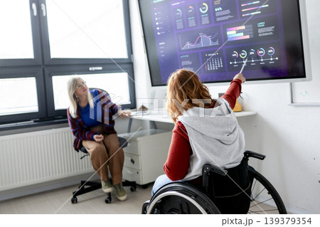 Female student in wheelchair presenting her project in front of classroom. Female student in wheelchair presenting her project in front of classroom. 139379354