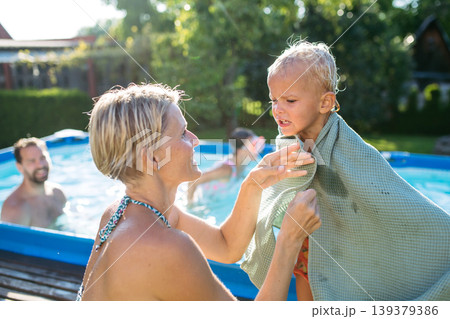 Mother drying off young son with towel. 139379386