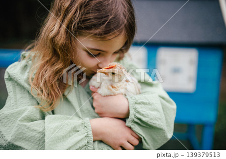 Girl taking care of chicken in family farm. 139379513