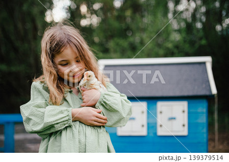 Girl taking care of chicken in family farm. Girl taking care of chicken in family farm. 139379514