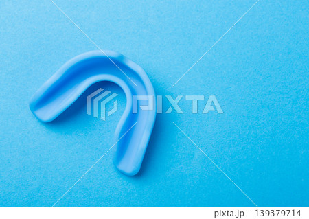 Sports dental protection mouthpiece for boxing and mma on a vibrant colored paper background. 139379714