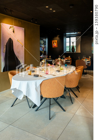 Festive dining setting. Spacious celebration room featuring round table and stylish decorations Festive dining setting. Spacious celebration room featuring round table and stylish decorations 139380790