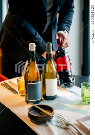 Wine service elegance. Attentive server presents and serves wine with style and finesse Wine service elegance. Attentive server presents and serves wine with style and finesse 139381129