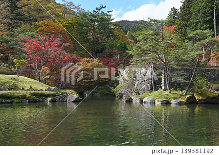 秋色に染まる回遊式庭園 池畔を彩る紅葉と重厚な石垣が織りなす日本の秋の風景 秋色に染まる回遊式庭園 池畔を彩る紅葉と重厚な石垣が織りなす日本の秋の風景 139381192