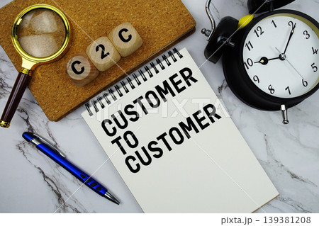 C2C Customer To Customer text written on notepad with magnifying glass and alarm clock on marble background 139381208