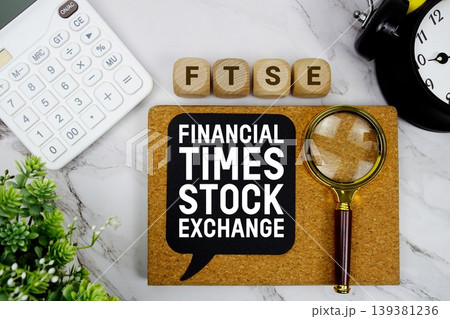 FTSE Financial Times Stock Exchange text with calculator, magnifying glass and alarm clock on marble background FTSE Financial Times Stock Exchange text with calculator, magnifying glass and alarm clock on marble background 139381236