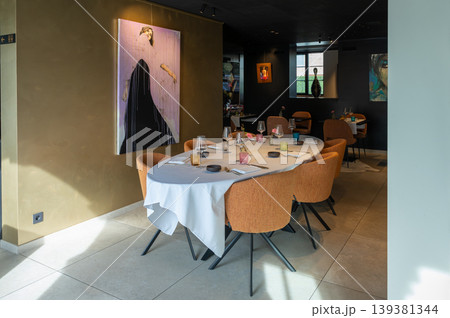 Extended dining arrangement. Large dining table partner with colorful art surroundings and elegant glassware 139381344
