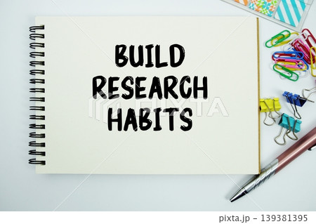 Build Research Habits text message written on notepad with stationery flat lay on white background Build Research Habits text message written on notepad with stationery flat lay on white background 139381395