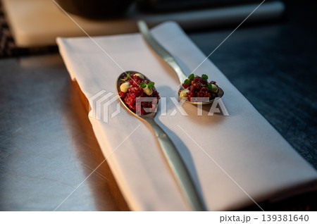 Gourmet dish on rustic table. Luxurious dining scene featuring delicate tartare and ambient lighting Gourmet dish on rustic table. Luxurious dining scene featuring delicate tartare and ambient lighting 139381640