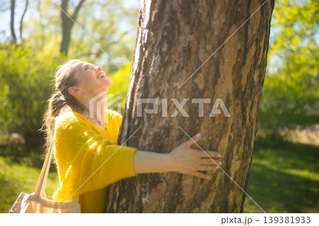 Woman Smiling While Connecting with Nature in a Forest Woman Smiling While Connecting with Nature in a Forest 139381933