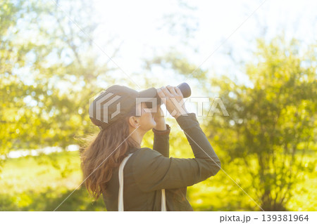 Enthusiastic Woman Birding in Sunlit Forest Enthusiastic Woman Birding in Sunlit Forest 139381964