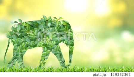 Elephant silhouette made of green leaves on sunny background. Ecology, global ecological resource, go green concept. Environmental conservation, wildlife protection, Eco-friendly, Green Energy 139382362