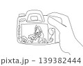 Minimalist one line drawing of a hand holding a digital camera showing a butterfly in public park. This nature concept is an amazing choice for Nature Photography Day coloring pages and wall decors. 139382444