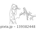 Single line drawing shows a handsome young man photographing a parrot in public garden. This impressive animal concept is brilliantly suited for Nature Photography Day articles and wildlife posters. 139382448