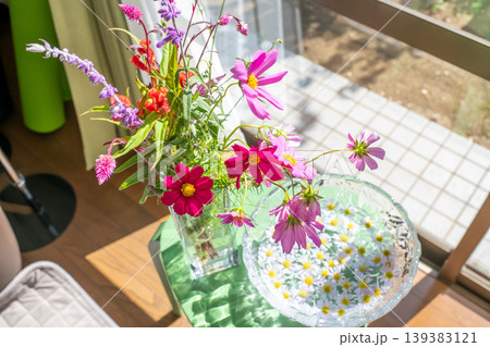 窓辺に飾られたコスモス・花瓶に浮かべられた花びら 139383121