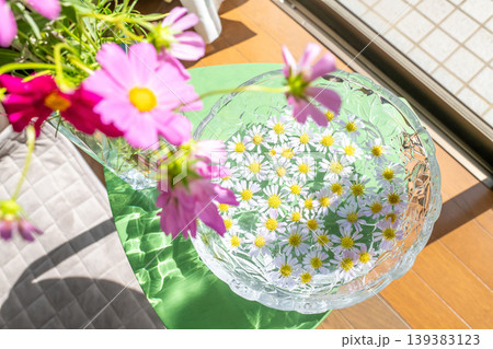 窓辺に飾られたコスモス・花瓶に浮かべられた花びら 窓辺に飾られたコスモス・花瓶に浮かべられた花びら 139383123