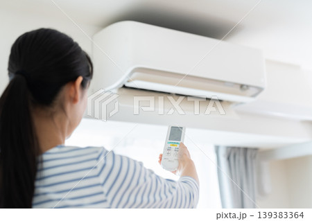 エアコンを操作する若い女性 139383364