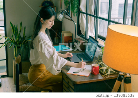自宅のデスクで仕事をする若い日本人女性 自宅のデスクで仕事をする若い日本人女性 139383538