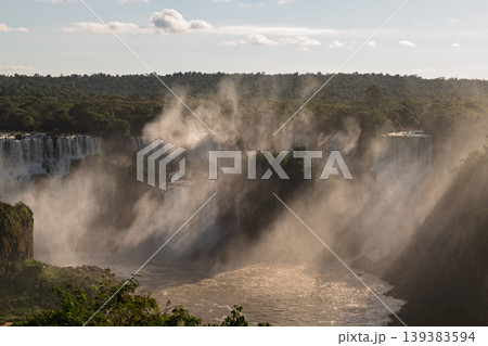 Majestic iguazu falls rushing powerful water creating dramatic mist in an inspiring landscape Majestic iguazu falls rushing powerful water creating dramatic mist in an inspiring landscape 139383594