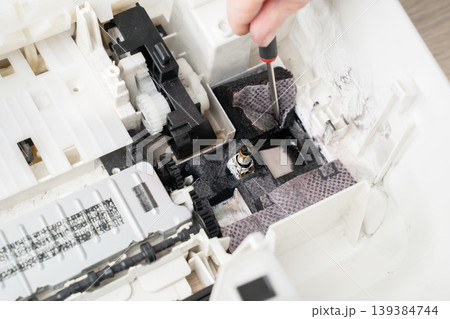 Close-up view of a printer interior showing ink and toner residue, gears, pads and plastic components, useful for repair, maintenance, troubleshooting and technical documentation of office equipment. Close-up view of a printer interior showing ink and toner residue, gears, pads and plastic components, useful for repair, maintenance, troubleshooting and technical documentation of office equipment. 139384744