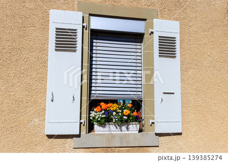 Beautiful flowers in a pot on the windowsill outside the house Beautiful flowers in a pot on the windowsill outside the house 139385274