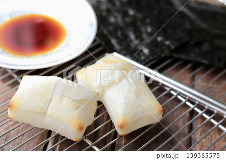 ケーキクーラの上に置いた磯辺焼き用の焼いた餅と醤油と焼き海苔 139385575