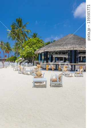 Tropical beach bar chairs tables sandy shore outdoors bar amazing luxury resort coastal scenery serene turquoise water summer vacation background exotic island destination tranquil horizon 139385771