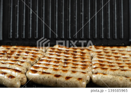 Delicious Pork Sausages Roasting on Contact Grill Surface 139385965