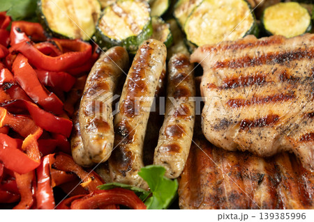 Assorted grilled meat, sausages and vegetables background Assorted grilled meat, sausages and vegetables background 139385996