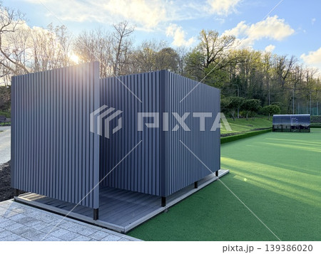 a outdoor modern locker room or shelter situated on the edge of an artificial turf soccer field. a outdoor modern locker room or shelter situated on the edge of an artificial turf soccer field. 139386020