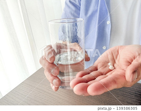 錠剤を水で飲む中年男性 139386305
