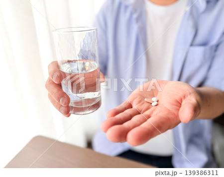 水で薬を飲む手元 139386311