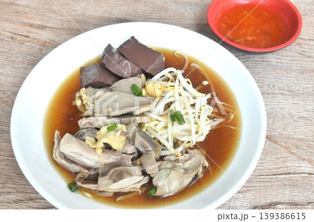 boiled slice duck meat with liver and blood in black soybean herb soup on plate dipping spicy sour chili sauce boiled slice duck meat with liver and blood in black soybean herb soup on plate dipping spicy sour chili sauce 139386615